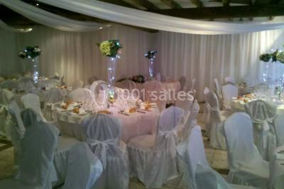 Salle de bain avec une douche à rideau blanc et violet, un lavabo avec serviettes pliées et un miroir mural.