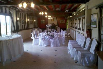 Salle de bain avec une douche à rideau blanc et violet, un lavabo avec serviettes pliées et un miroir mural.