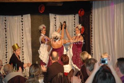 Salle de bain avec une douche à rideau blanc et violet, un lavabo avec serviettes pliées et un miroir mural.