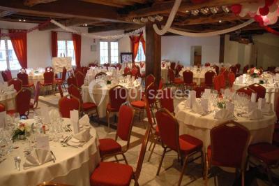 Salle de bain avec une douche à rideau blanc et violet, un lavabo avec serviettes pliées et un miroir mural.
