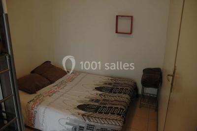 Salle de bain avec une douche à rideau blanc et violet, un lavabo avec serviettes pliées et un miroir mural.