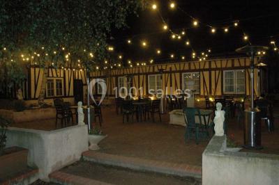 Salle de bain avec une douche à rideau blanc et violet, un lavabo avec serviettes pliées et un miroir mural.