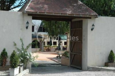 Salle de bain avec une douche à rideau blanc et violet, un lavabo avec serviettes pliées et un miroir mural.
