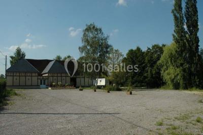 Salle de bain avec une douche à rideau blanc et violet, un lavabo avec serviettes pliées et un miroir mural.
