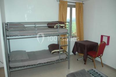 Salle de bain avec une douche à rideau blanc et violet, un lavabo avec serviettes pliées et un miroir mural.
