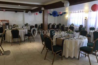 Salle de bain avec une douche à rideau blanc et violet, un lavabo avec serviettes pliées et un miroir mural.