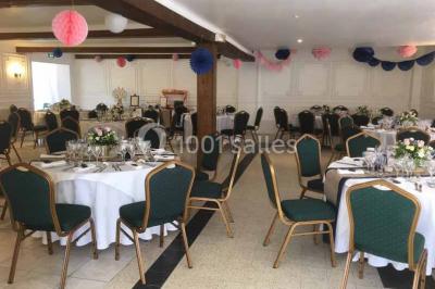 Salle de bain avec une douche à rideau blanc et violet, un lavabo avec serviettes pliées et un miroir mural.