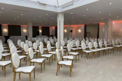 Macaron rose garni de crème, décoré d'une fraise, d'une framboise, d'une fleur comestible et de coulis rouge.