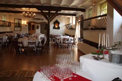 Chaises blanches en plastique disposées sur une pelouse ombragée, avec une tente et un jardin en arrière-plan.