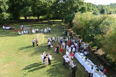 Un groupe de personnes assises dans une salle en bois assistent à une cérémonie officielle.