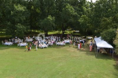 Un groupe de personnes assises dans une salle en bois assistent à une cérémonie officielle.