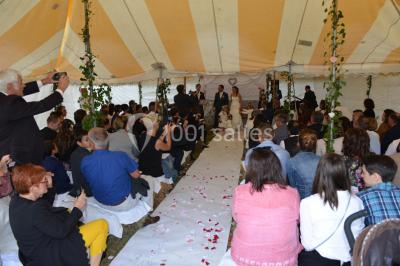 Un groupe de personnes assises dans une salle en bois assistent à une cérémonie officielle.