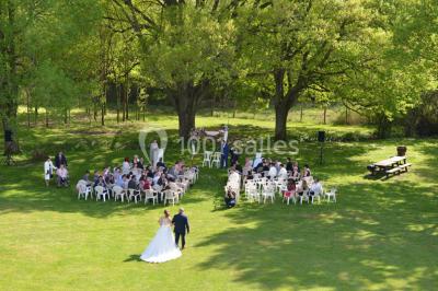 Un groupe de personnes assises dans une salle en bois assistent à une cérémonie officielle.