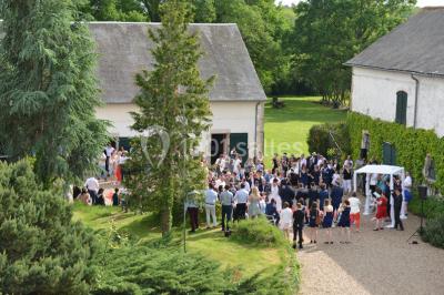 Un groupe de personnes assises dans une salle en bois assistent à une cérémonie officielle.