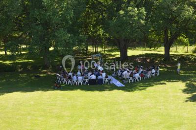 Un groupe de personnes assises dans une salle en bois assistent à une cérémonie officielle.