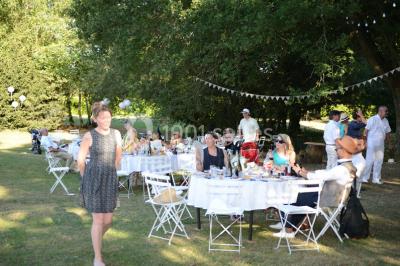 Un groupe de personnes assises dans une salle en bois assistent à une cérémonie officielle.