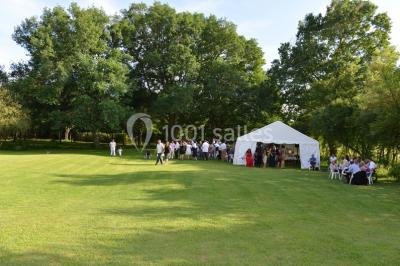 Un groupe de personnes assises dans une salle en bois assistent à une cérémonie officielle.