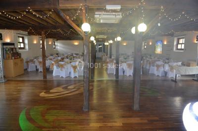 Un groupe de personnes assises dans une salle en bois assistent à une cérémonie officielle.