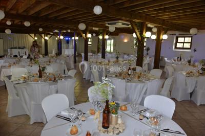 Un groupe de personnes assises dans une salle en bois assistent à une cérémonie officielle.