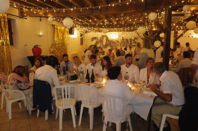 Un groupe de personnes assises dans une salle en bois assistent à une cérémonie officielle.