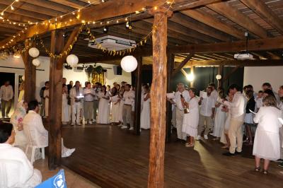 Un groupe de personnes assises dans une salle en bois assistent à une cérémonie officielle.
