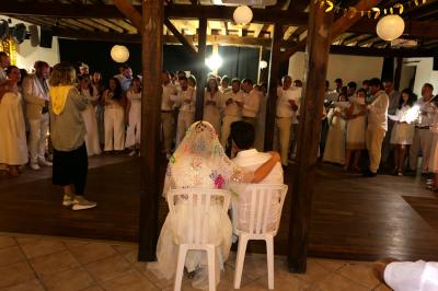 Un groupe de personnes assises dans une salle en bois assistent à une cérémonie officielle.