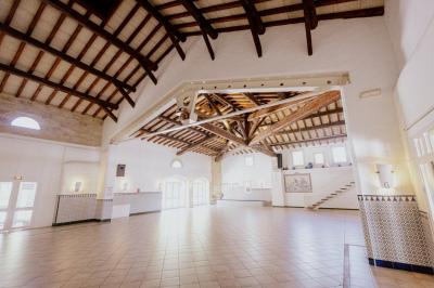 Une jument blanche et son poulain brun broutent dans un champ verdoyant bordé d'arbres.