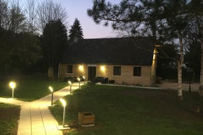 Chambre lumineuse avec lit double, bureau, télévision murale, fauteuil et fenêtre donnant sur l'extérieur.