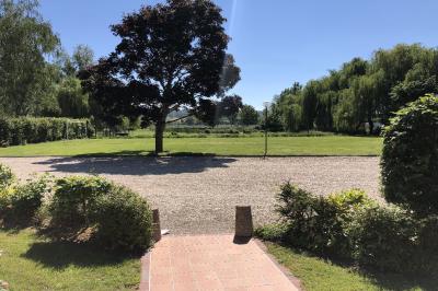 Chambre lumineuse avec lit double, bureau, télévision murale, fauteuil et fenêtre donnant sur l'extérieur.