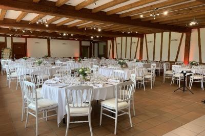 Chambre lumineuse avec lit double, bureau, télévision murale, fauteuil et fenêtre donnant sur l'extérieur.