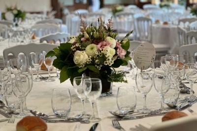 Chambre lumineuse avec lit double, bureau, télévision murale, fauteuil et fenêtre donnant sur l'extérieur.