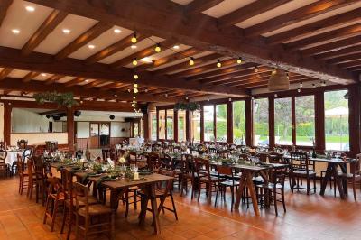 Chambre lumineuse avec lit double, bureau, télévision murale, fauteuil et fenêtre donnant sur l'extérieur.