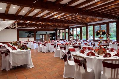 Chambre lumineuse avec lit double, bureau, télévision murale, fauteuil et fenêtre donnant sur l'extérieur.