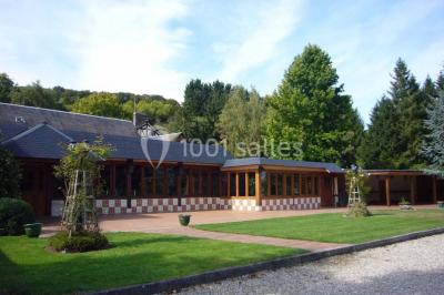 Chambre lumineuse avec lit double, bureau, télévision murale, fauteuil et fenêtre donnant sur l'extérieur.