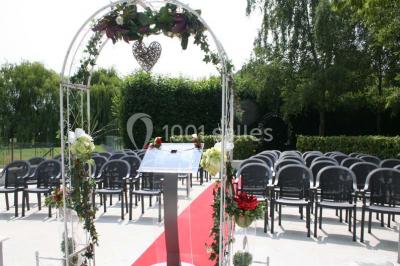 Chambre lumineuse avec lit double, bureau, télévision murale, fauteuil et fenêtre donnant sur l'extérieur.