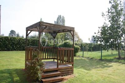 Chambre lumineuse avec lit double, bureau, télévision murale, fauteuil et fenêtre donnant sur l'extérieur.