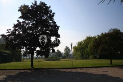 Chambre lumineuse avec lit double, bureau, télévision murale, fauteuil et fenêtre donnant sur l'extérieur.