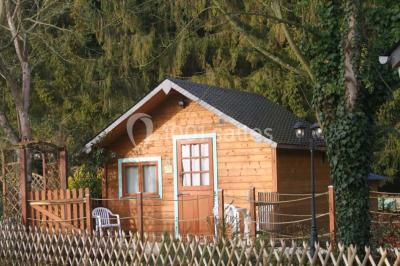 Chambre lumineuse avec lit double, bureau, télévision murale, fauteuil et fenêtre donnant sur l'extérieur.