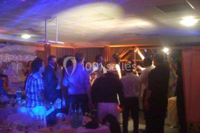 Vue nocturne depuis une fenêtre, montrant un parc éclairé, des arbres et des bâtiments en arrière-plan.