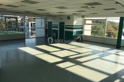 Vue nocturne depuis une fenêtre, montrant un parc éclairé, des arbres et des bâtiments en arrière-plan.