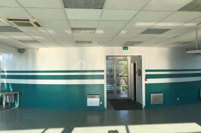 Vue nocturne depuis une fenêtre, montrant un parc éclairé, des arbres et des bâtiments en arrière-plan.