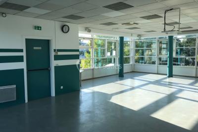 Vue nocturne depuis une fenêtre, montrant un parc éclairé, des arbres et des bâtiments en arrière-plan.