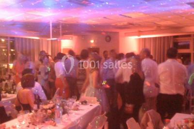 Vue nocturne depuis une fenêtre, montrant un parc éclairé, des arbres et des bâtiments en arrière-plan.