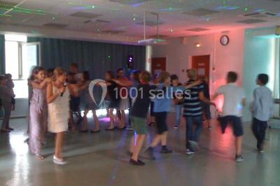 Vue nocturne depuis une fenêtre, montrant un parc éclairé, des arbres et des bâtiments en arrière-plan.