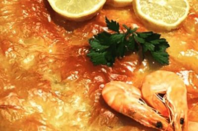 Assiette garnie de légumes variés, morceaux de viande et sauce rouge au centre, présentée sur un lit de salade.