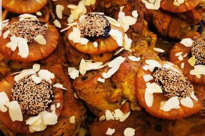Assiette garnie de légumes variés, morceaux de viande et sauce rouge au centre, présentée sur un lit de salade.