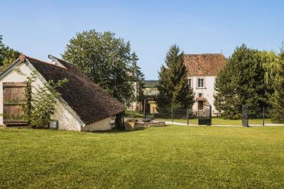 Lit simple avec une tête de lit en bois, couvert d'une couverture à motifs tropicaux, dans une chambre lumineuse.
