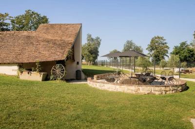 Lit simple avec une tête de lit en bois, couvert d'une couverture à motifs tropicaux, dans une chambre lumineuse.