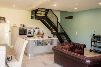 Lit simple avec une tête de lit en bois, couvert d'une couverture à motifs tropicaux, dans une chambre lumineuse.