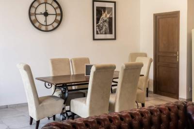 Lit simple avec une tête de lit en bois, couvert d'une couverture à motifs tropicaux, dans une chambre lumineuse.